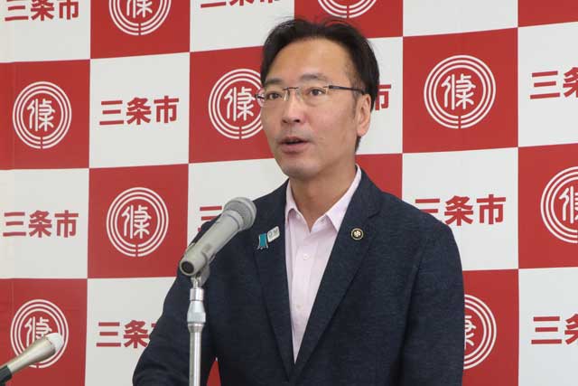 記者会見する国定市長