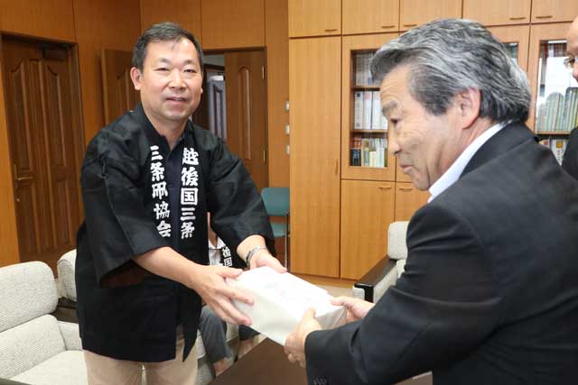 長谷川教育長(右)にDVDを手渡す須藤三条凧協会会長