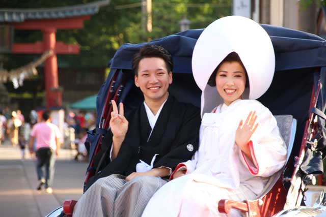 あかりの結婚式で宮大門で人力車に乗って祝福に応える大竹さん夫婦