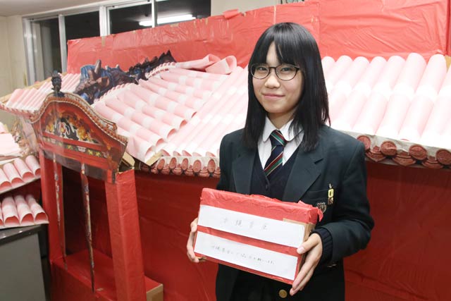 募金箱を手に製作の中心になった武田さん