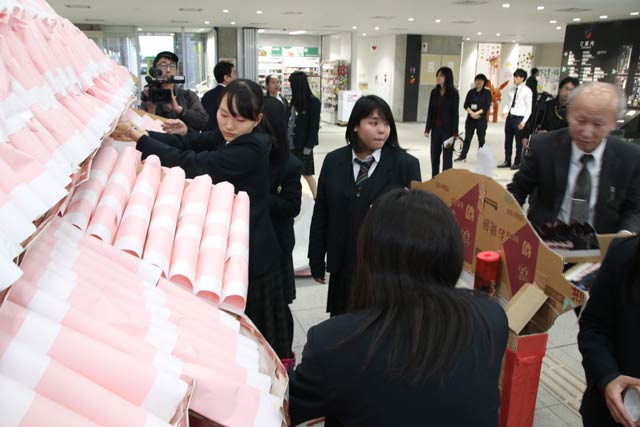 段ボール製の首里城を組み立てる生徒