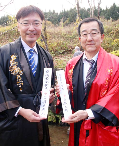 流觴曲水宴で短冊に詩を書いた國定三条市長(左)と孫中国駐新潟総領事