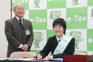 決済の印を押す雨宮1日税務署長と長谷川税務署長
