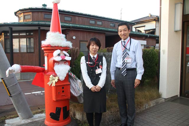 サンタクロースにふんした丸型ポストと粟生津郵便局の小平局長と原口主任