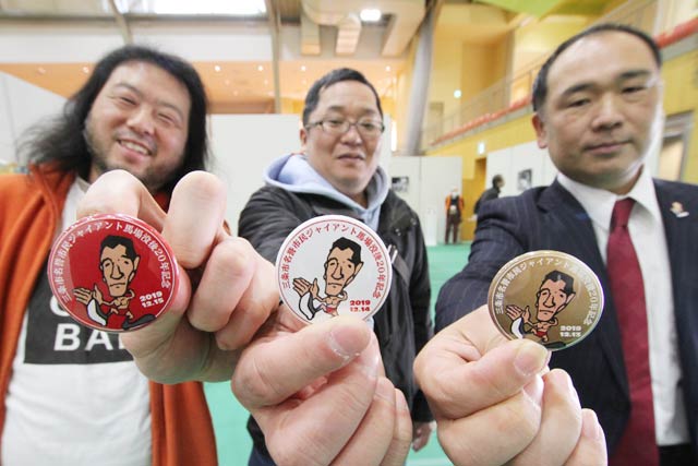 配布している缶バッジと三条ジャイアント馬場倶楽部の会員、いちばん右が中條会長