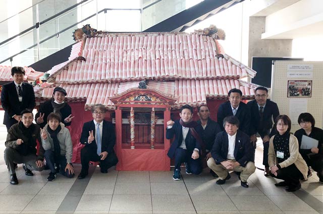 燕市役所に展示された段ボール首里城の前でモスバーガー共栄会沖縄支部