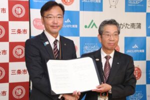 協定書を手に国定市長(左)と佐野理事長