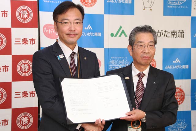 協定書を手に国定市長(左)と佐野理事長