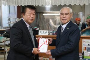 ふれあい喫茶「ぽぽ」でグローバルの柳原社長(左)から燕市社会福祉協議会の山岡会長に寄付を手渡す