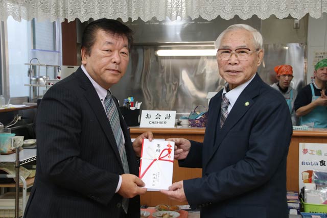 ふれあい喫茶「ぽぽ」でグローバルの柳原社長(左)から燕市社会福祉協議会の山岡会長に寄付を手渡す