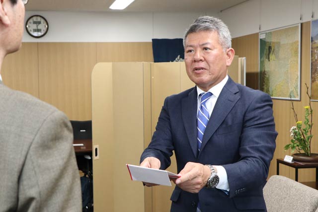 寄付の目録を鈴木市長に手渡す森井社長