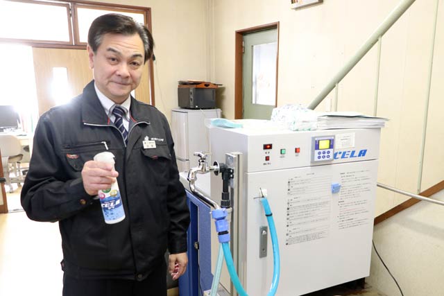 CELA水生成装置の前でCELA水を手にホクエツの浅野社長