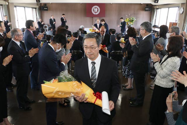 後輩職員の拍手に送られて退場する退職者