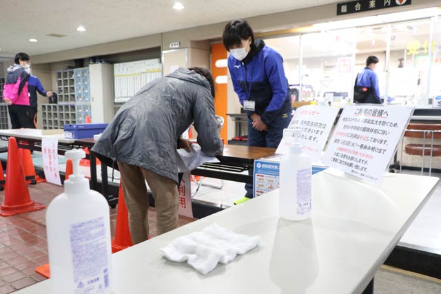 利用前に手指を除菌し個人利用書に記入する燕市体育センター