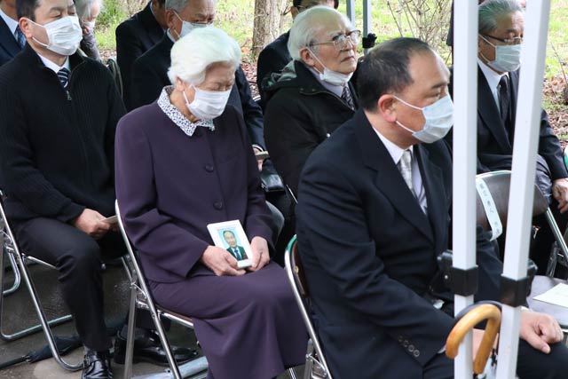 発起人の故中條耕二さんの遺影を抱く妻の敦子さん