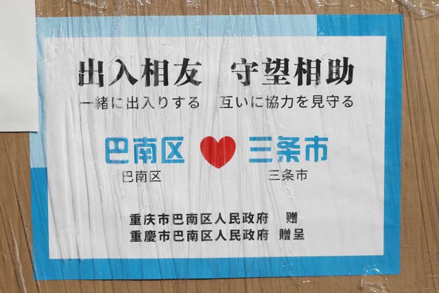 段ボール箱には「出入相友　守望相助」