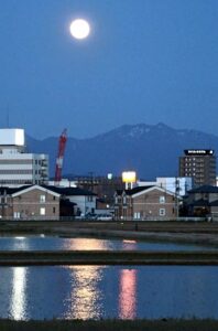 燕三条駅付近で粟ヶ岳の上で輝くフラワームーンの光が田んぼの水にきらきら反射