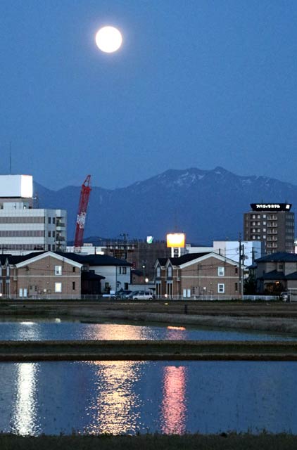 燕三条駅付近で粟ヶ岳の上で輝くフラワームーンの光が田んぼの水にきらきら反射