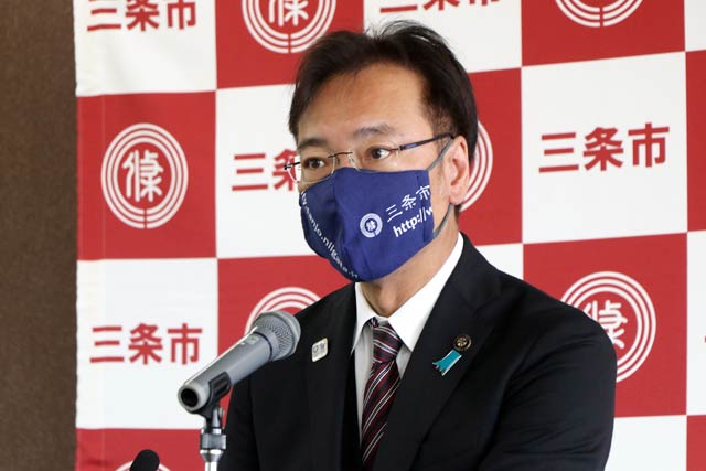 記者会見する国定市長