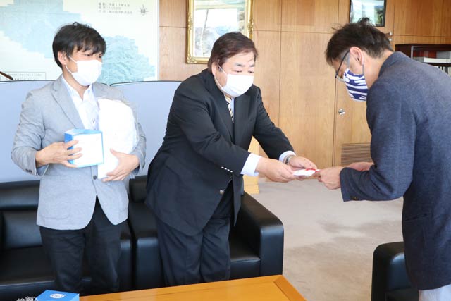 国定市長に寄付の目録を手渡すナリタ工業の成田社長(中央)