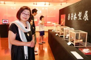 栃尾文化センターで開かれている菓子木型展で展示されている木型を所有する「おさべ菓子店」の長部恵子さん