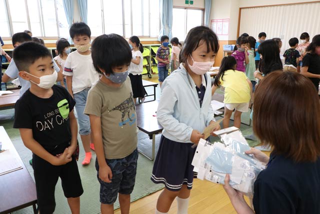 燕市職員から児童一人ひとりにマスクを手渡す