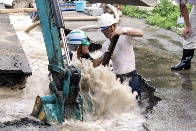 弥彦神社第一駐車場で水道管破損の復旧工事で水道管本管の穴に杭を刺す作業