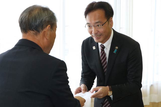 佐藤議長に退職申出を手渡す国定市長