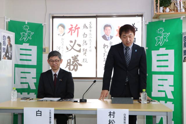 記者会見であいさつする後援会長の村松氏