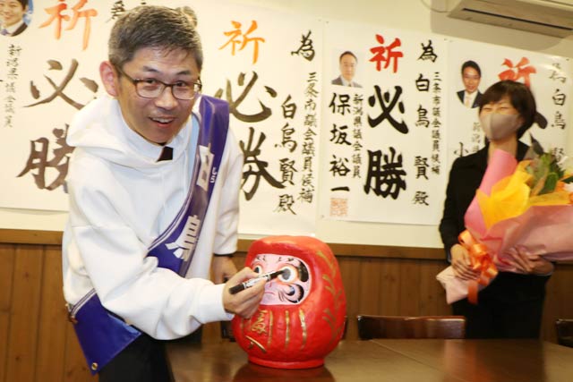 だるまに目を入れる白鳥氏