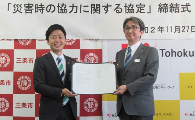 署名した協定書を手に滝沢三条市長(左)と東北電力ネットワーク株式会社新潟県央電力センターの寒河江所長
