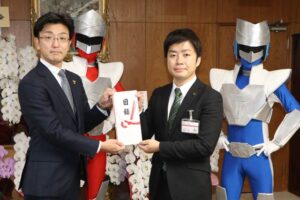 燕三条戦隊カジレンジャーを背に三条商工会議所青年部の新保会長(左)と滝沢市長