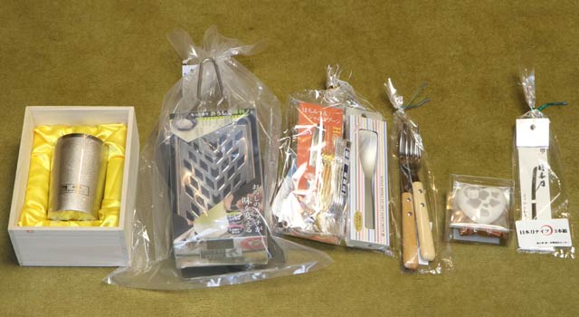 新春おみくじの商品のチタン製タンブラー、お楽しみ袋の商品、丑年生まれへの新春プレゼント、1万円以上の買い上げでもらえる日本刀がモチーフの和菓子ナイフ