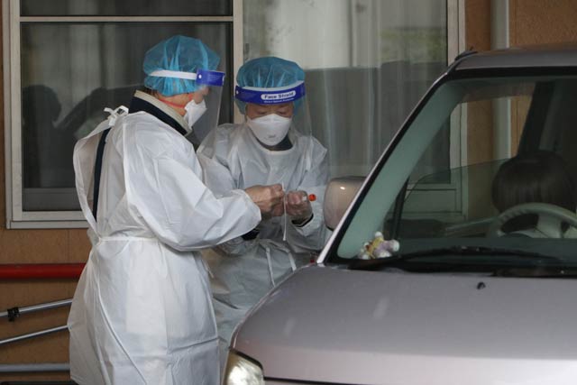 玄関前でドライブスルー形式でPCR検査の検体採取