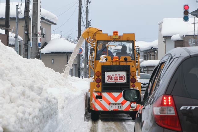 12日昼、北三条駅裏で道路の拡幅作業を行う除雪車