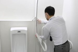 新たに男子トイレの小便器の間にパーティションを設置