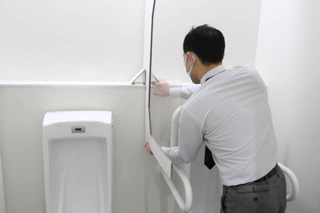 新たに男子トイレの小便器の間にパーティションを設置