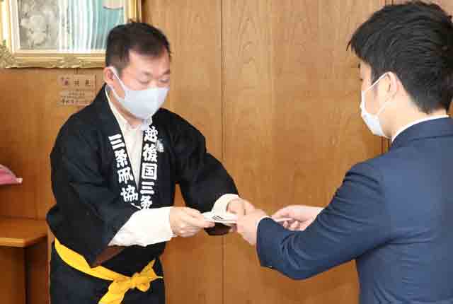 須藤会長から滝沢市長に目録を手渡す