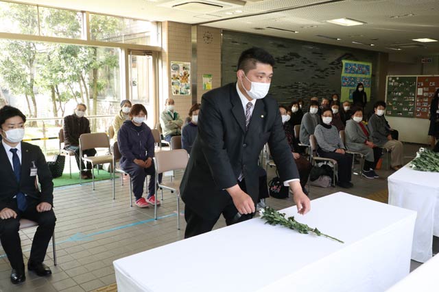 献花する避難者代表の佐藤聖之さん