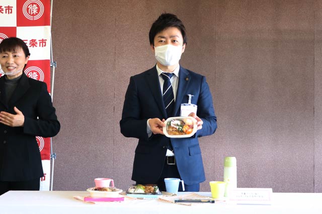 13日の定例記者会見で弁当を紹介する滝沢市長