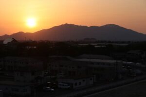 2日夕方の弥彦山に沈む夕日を三条市立大学屋上から