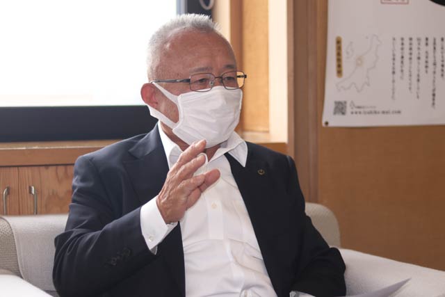 8日に弥彦村役場で報道関係者に説明する小林村長