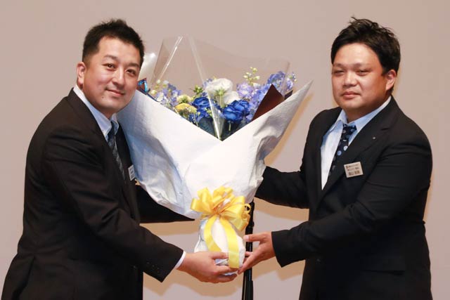 次年度会長に決まった加藤克宏さん(左)に花束を渡す森山辰典会長