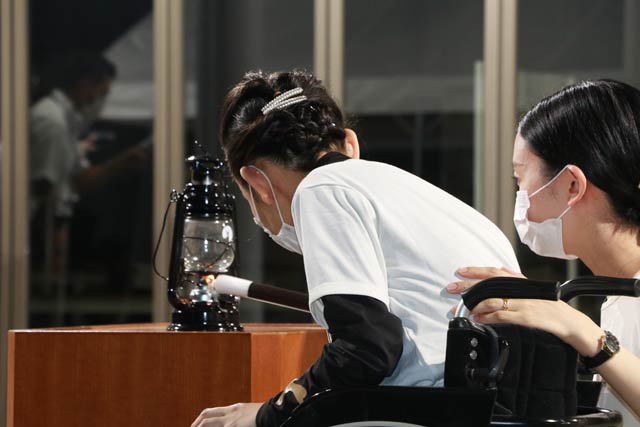 坂田さんがろうそくの火をランタンに移す