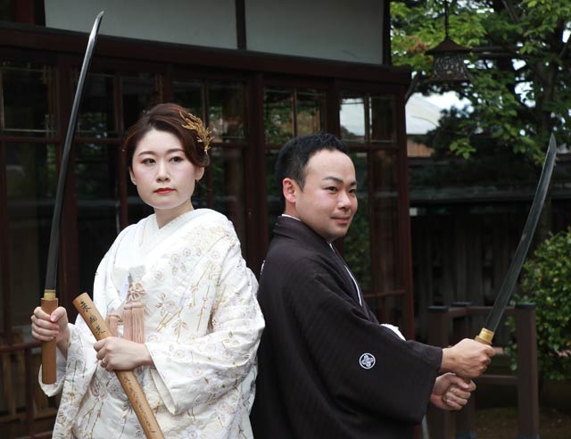 真剣を手に結婚式の前撮りをする菊田さん夫婦、茉祐さんが持つのが鎌倉末期の山城国の名工、来国光の太刀