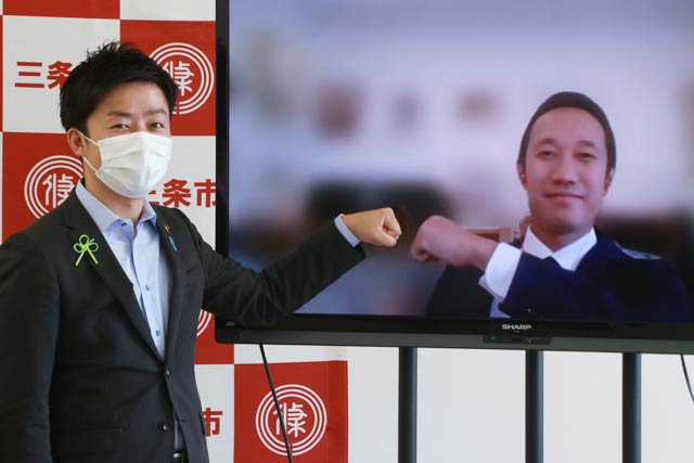 三条市のふるさと納税のCMOに決まった澤さん(右)、三条市長の記者会見にリモート参加して滝沢市長とリモートでグータッチ 