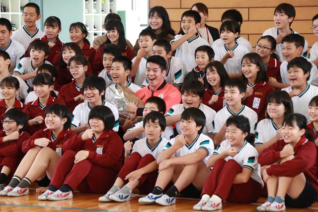 子どもたちと記念写真に写る水沼選手