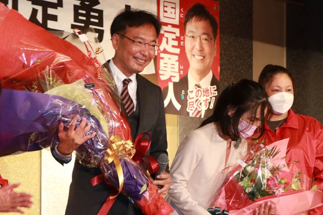 花束を受ける国定氏と妻の律子さん