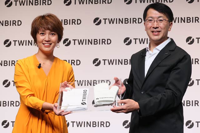 ツインバード工業の「スチームオーブンレンジ」のアンバサダーに就任した和田明日香さんに野水社長から新しいロゴをデザインしたエプロンとミトンを贈呈