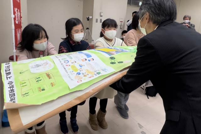 加納河川管理課長に大型ポスターを手渡す4年生